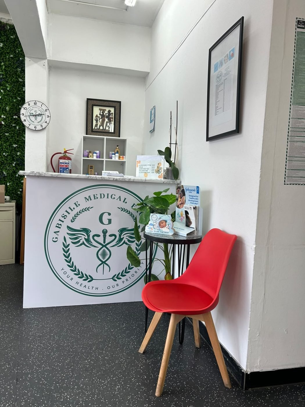 The Gabisile reception desk with the clinic crest
